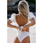 Woman wearing a white swimsuit on a beach