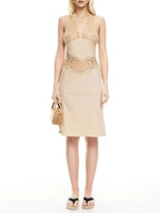 Woman wearing a beige dress with lace details on a white background