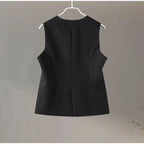 Black sleeveless dress on a hanger against a plain background.