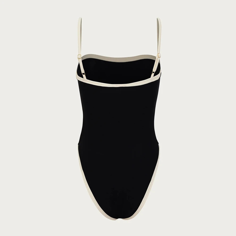 Black swimsuit with thin straps on a light gray background