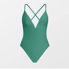 Green swimsuit with criss-cross straps on a light gray background