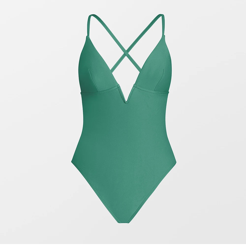 Green swimsuit with criss-cross straps on a light gray background