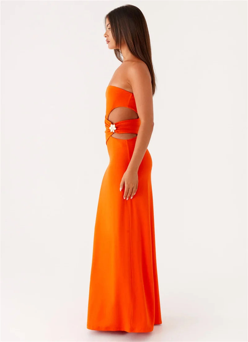 Woman wearing an orange strapless dress with cut-out design on a white background