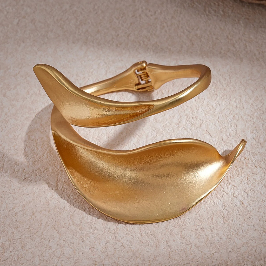 Gold bracelet on a textured beige surface