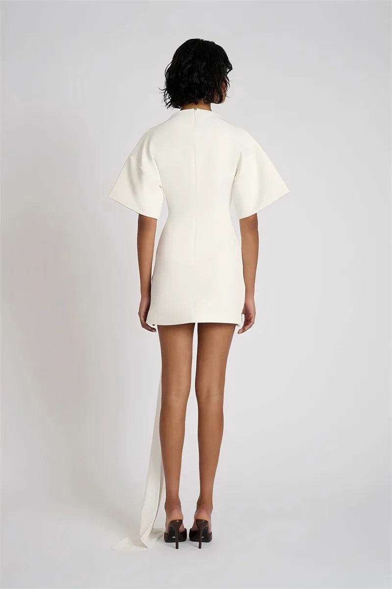 Person wearing a white dress with a plain background