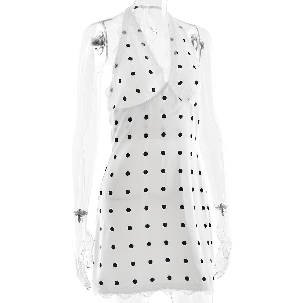 White sleeveless top with black polka dots on a white background