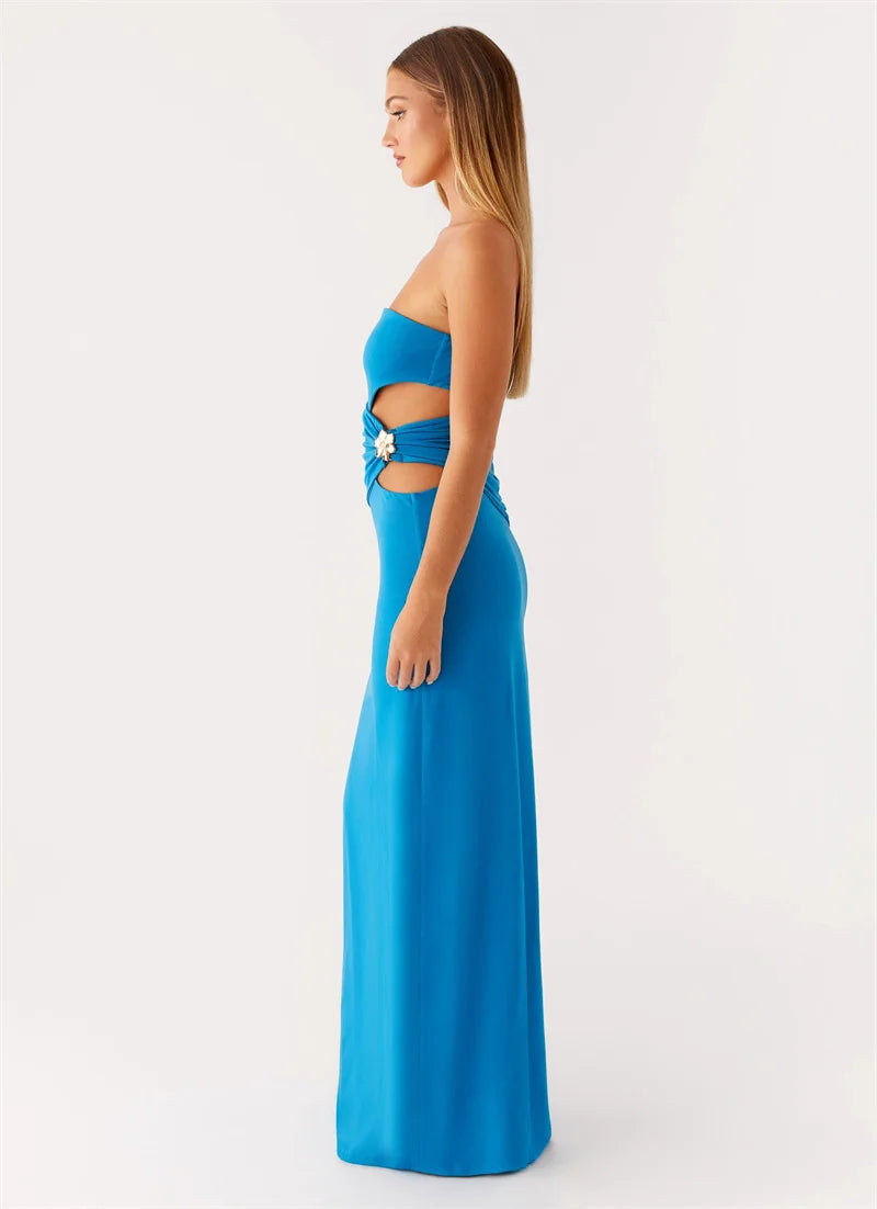 Woman wearing a blue strapless gown with cut-out design on a white background