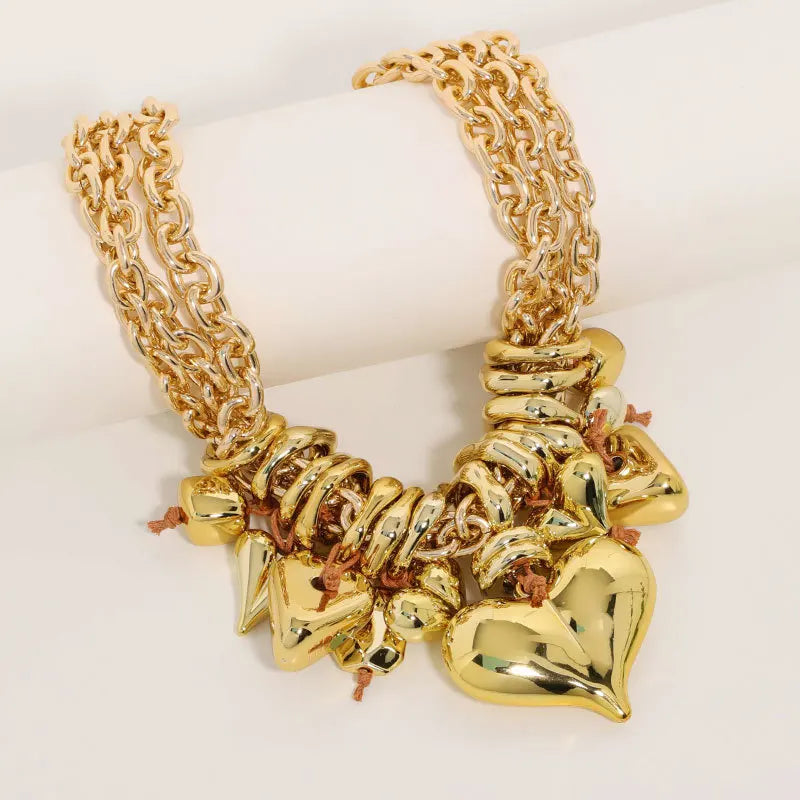 Gold necklace with heart-shaped pendants on a white background
