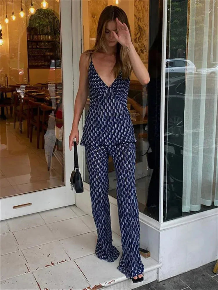 Woman in a patterned outfit standing in front of a store.