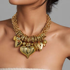 Gold necklace with heart-shaped pendants on a person against a neutral background