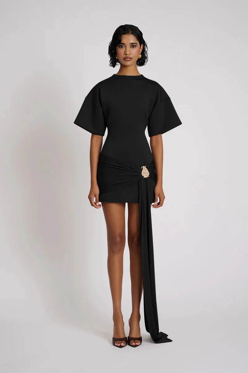 Woman wearing a black dress with a sheer side panel on a white background