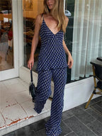 Woman in a blue patterned outfit standing on a street.