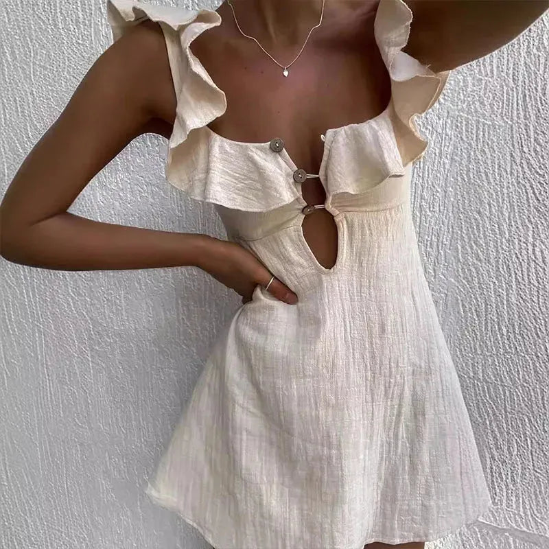 Beige and white dress with ruffled straps against a textured white background.