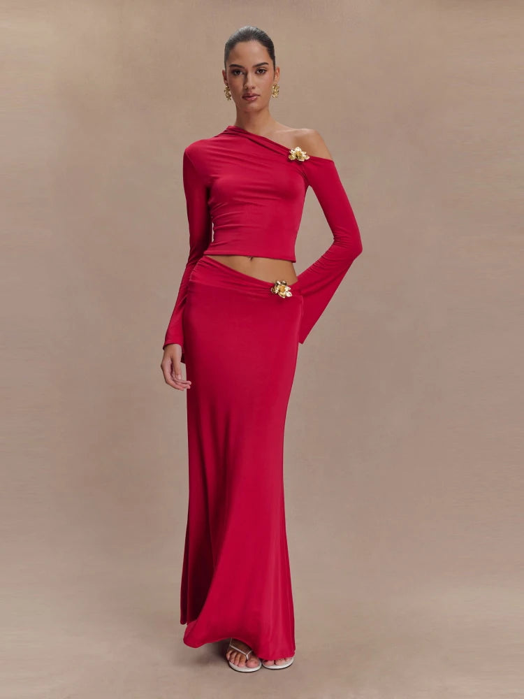 Woman wearing a red one-shoulder dress with gold accents on a beige background