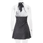 Black and white polka dot dress with a sheer overlay on a mannequin against a white background