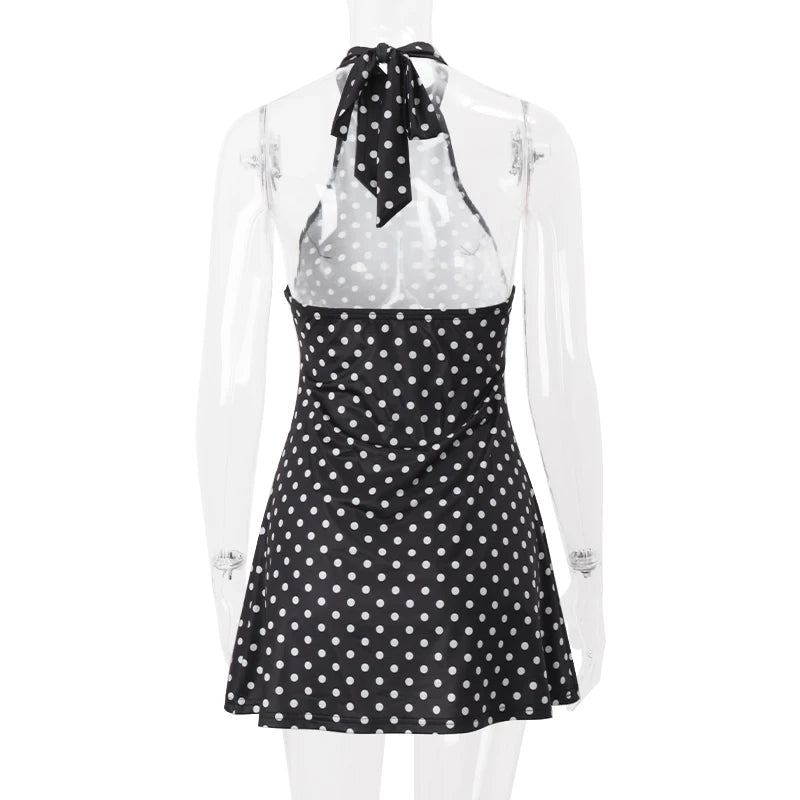 Black and white polka dot dress with a sheer overlay on a mannequin against a white background