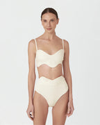 Woman wearing a beige swimsuit on a white background