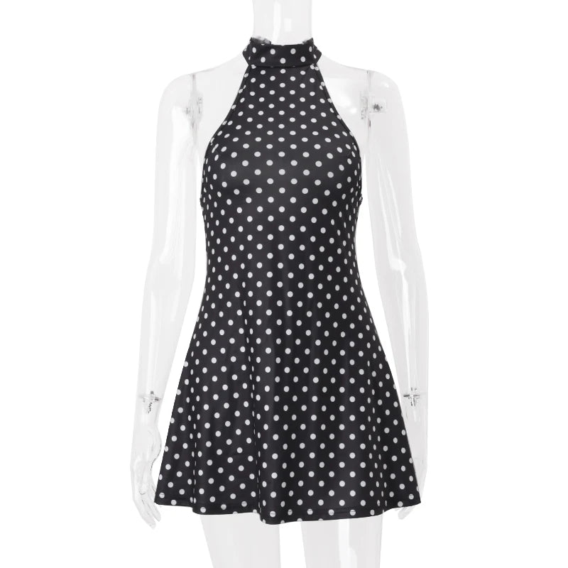 Black dress with white polka dots on a mannequin against a white background