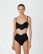 Woman wearing a black swimsuit on a white background