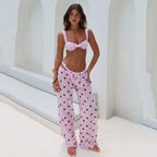 Woman wearing a pink polka dot bikini and matching pants in a bright setting