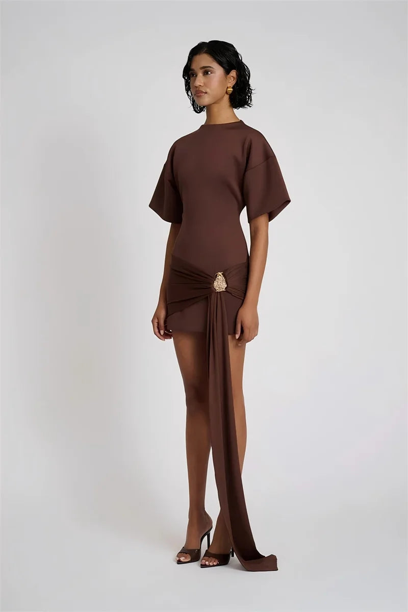 Woman wearing a brown dress with a draped design on a white background