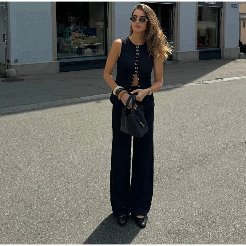 Woman in black outfit standing on a street