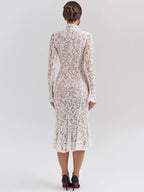 Woman wearing a white lace dress against a gray background