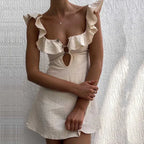 White dress with ruffled details on a textured white background