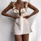 A beige mini dress with hollow out and ruffles, displayed on a model against a white background.