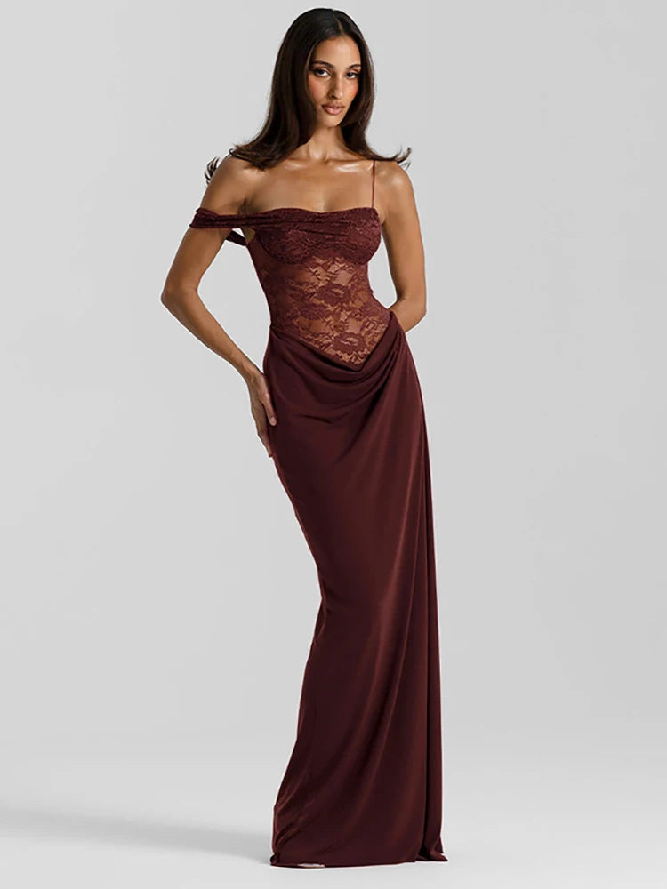 Woman wearing a burgundy evening gown with lace detailing on a light gray background