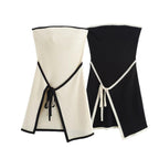 A white strapless mini dress with a solid backless design above knee, featuring a black belt.