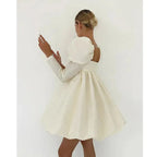 Person wearing a white dress against a plain background