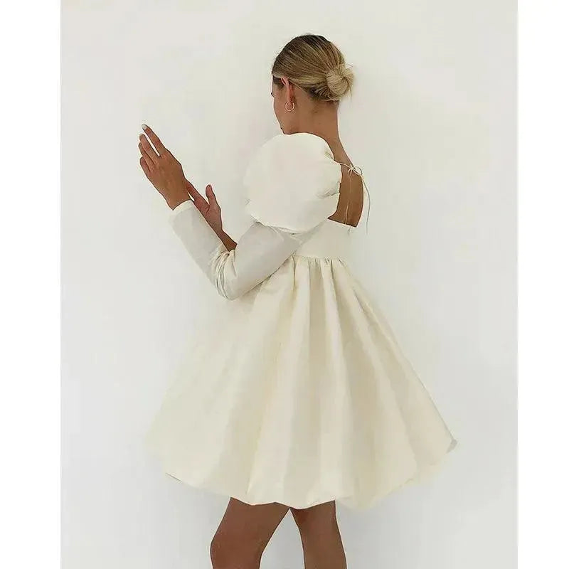 Person wearing a white dress against a plain background