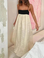 Woman wearing a black and white dress in a room with pink walls.