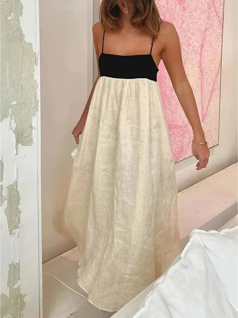 Woman wearing a black and white dress in a room with pink walls.