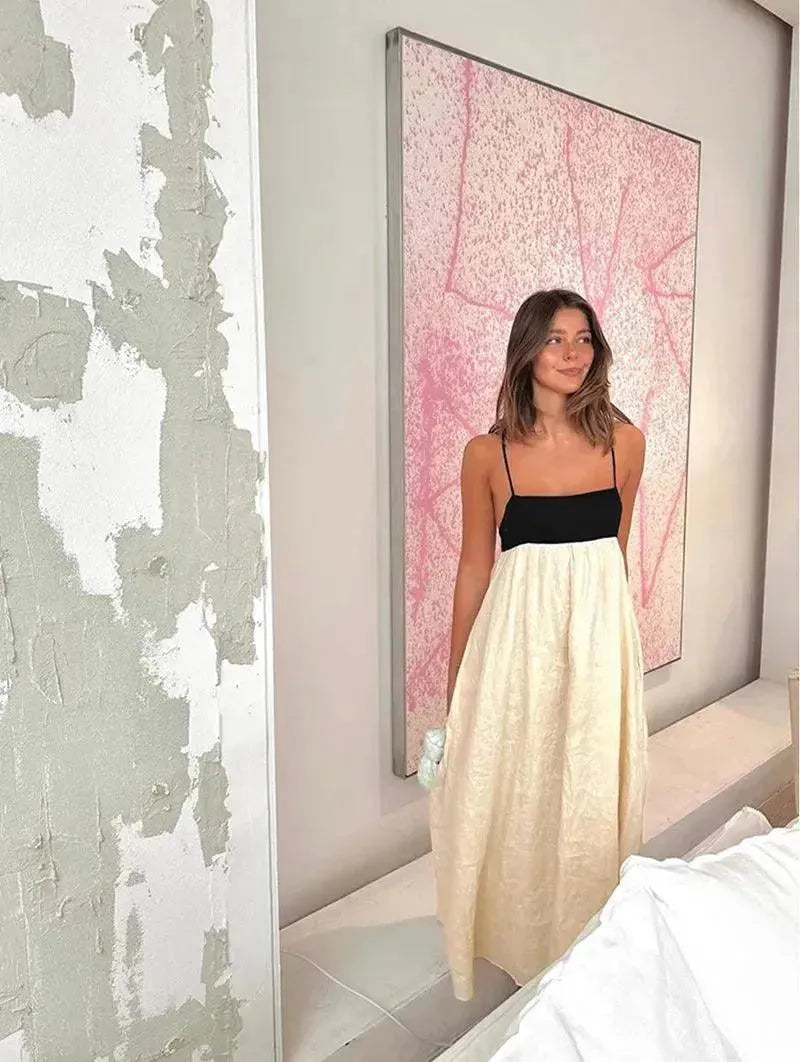 Woman in a white and black dress standing in a room with a pink abstract painting.
