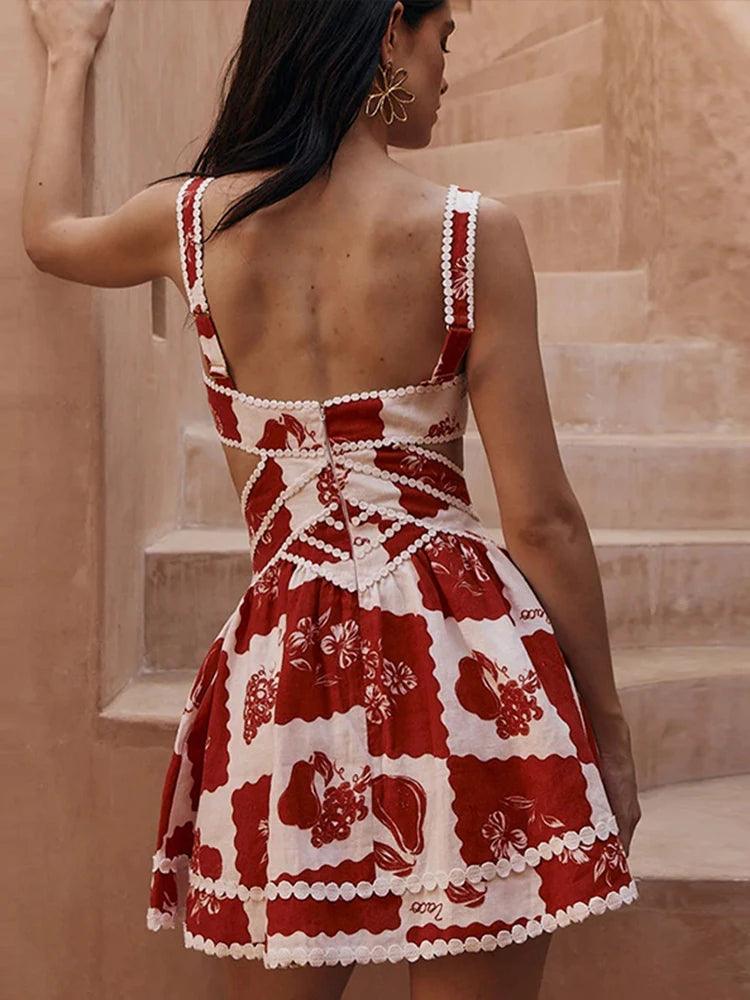 A woman wearing a red and white floral mini dress with a V-neck and sleeveless design, standing on a staircase.