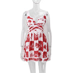 A woman wearing a red and white floral mini dress with a V-neck and sleeveless design, standing on a staircase.