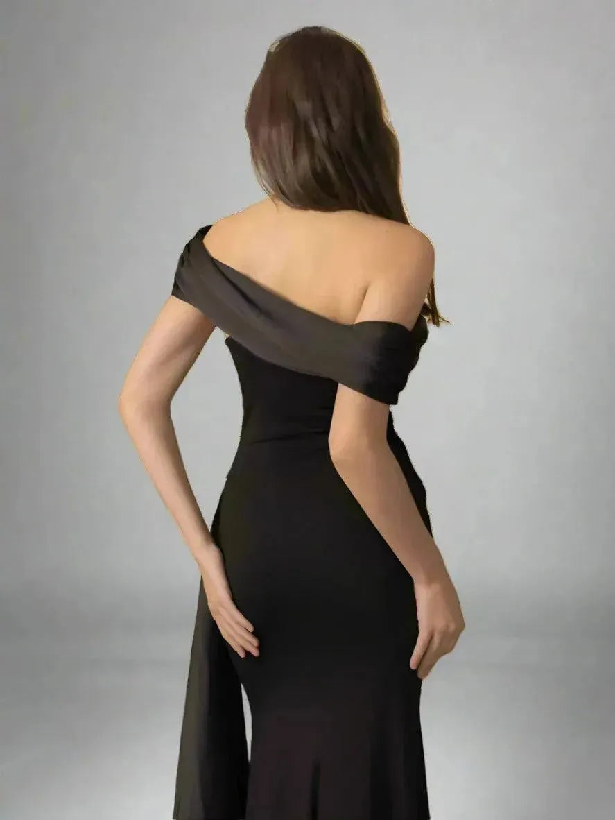 Woman wearing a black evening gown against a gray background