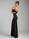 Woman wearing a black evening gown against a plain background