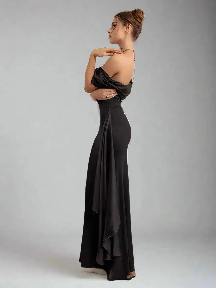 Woman wearing a black evening gown against a plain background