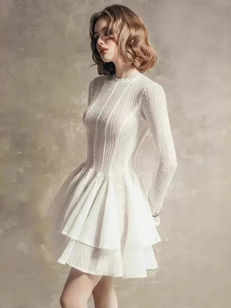 Woman wearing a white textured dress against a neutral background