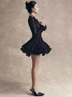 Woman in a black dress against a neutral background