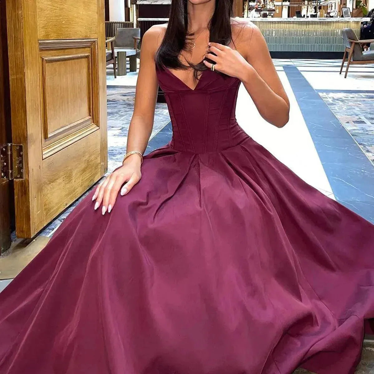 Woman in a burgundy dress in a courtyard setting