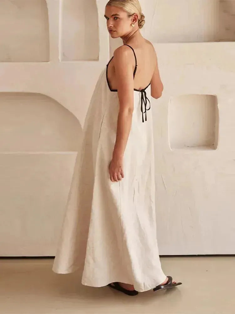 Woman in a white dress with black straps in a minimalistic setting