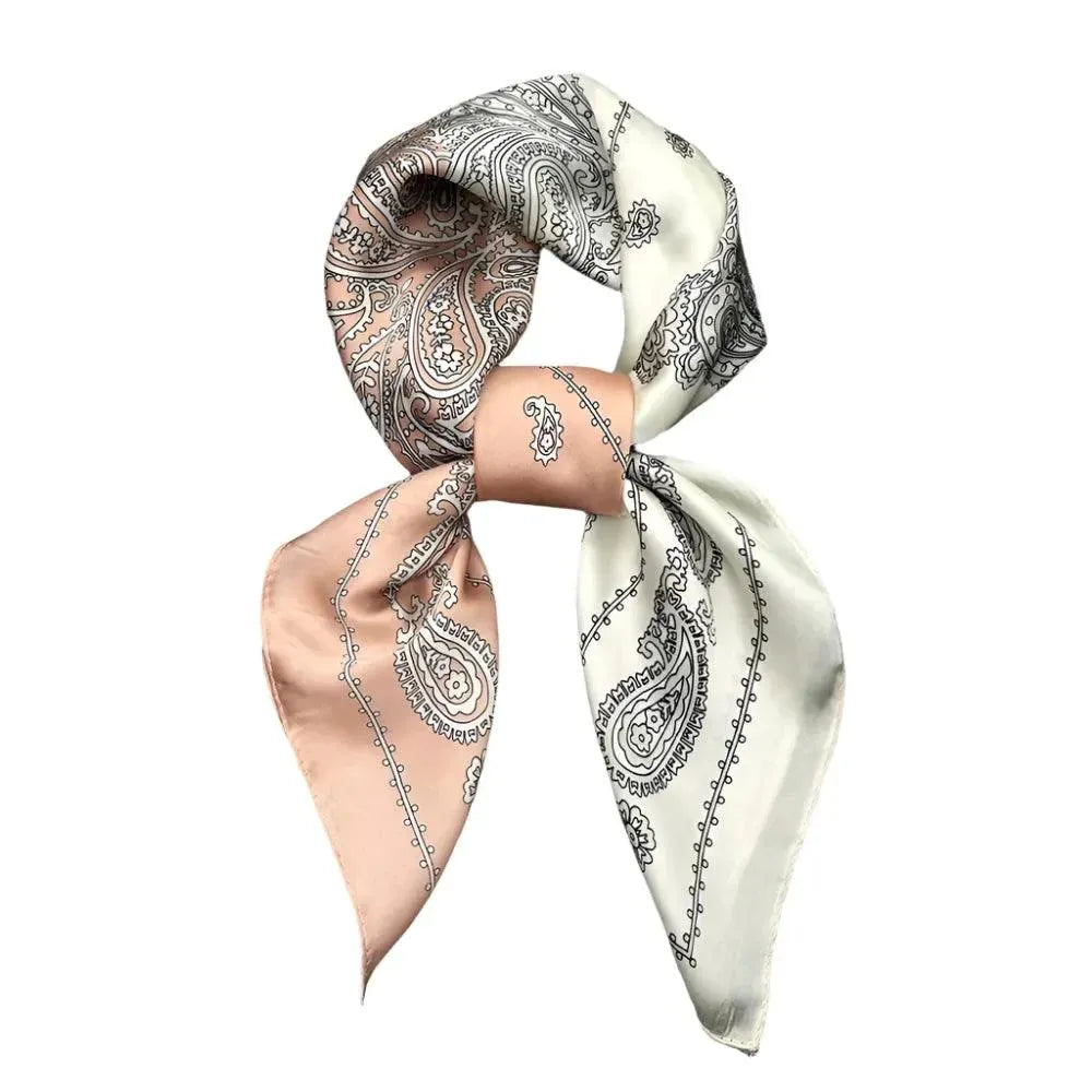 A silk shawl with a geometric parsley pattern, featuring beige and navy colors, draped as a square scarf.