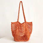 An orange hollow fishnet handbag with a shoulder strap on a white background.