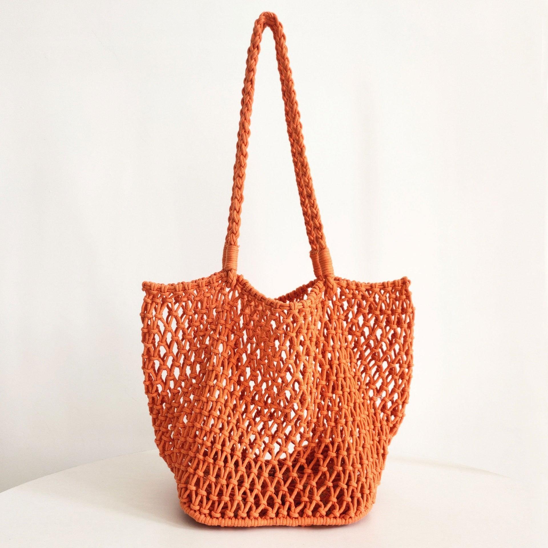 An orange hollow fishnet handbag with a shoulder strap on a white background.